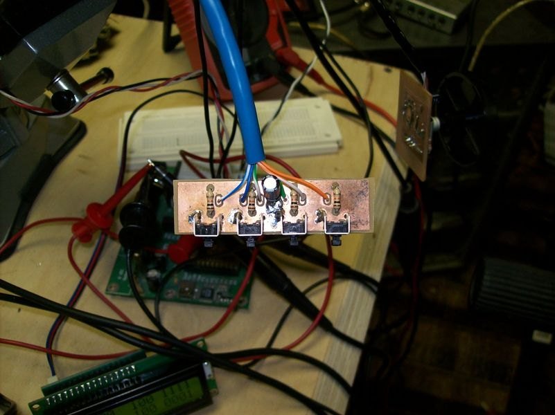 Microcontroller, LCD and perfboard mid-development. Breadboard wire everywhere, which is the correct amount.