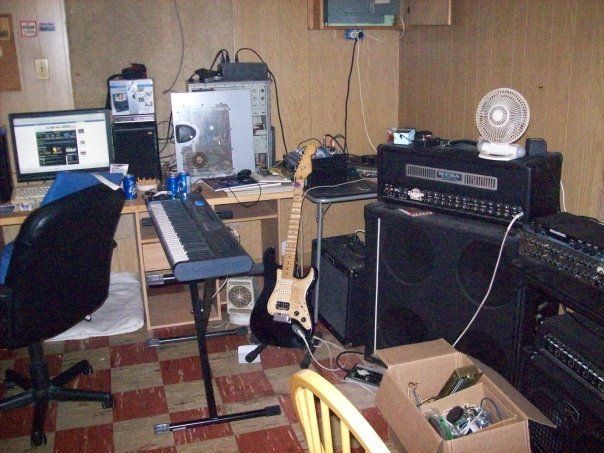The bench. Amps, monitors, keyboard, and a computer doing three jobs badly.