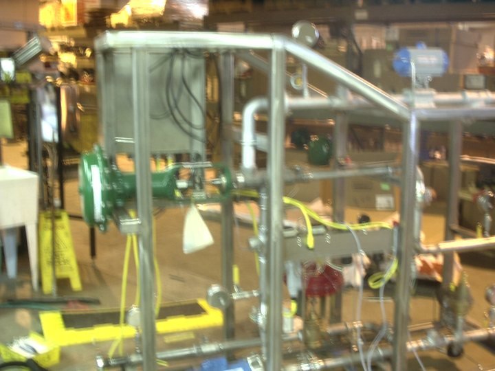 Stainless frame with the process piping in. Built at bench height, where it can still be reached from all four sides.