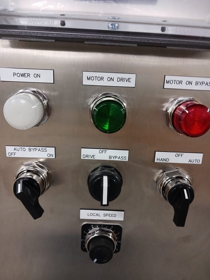 Hard operator station. Power on, motor on, motor off, selector. Legible from across the aisle and operable wearing gloves.