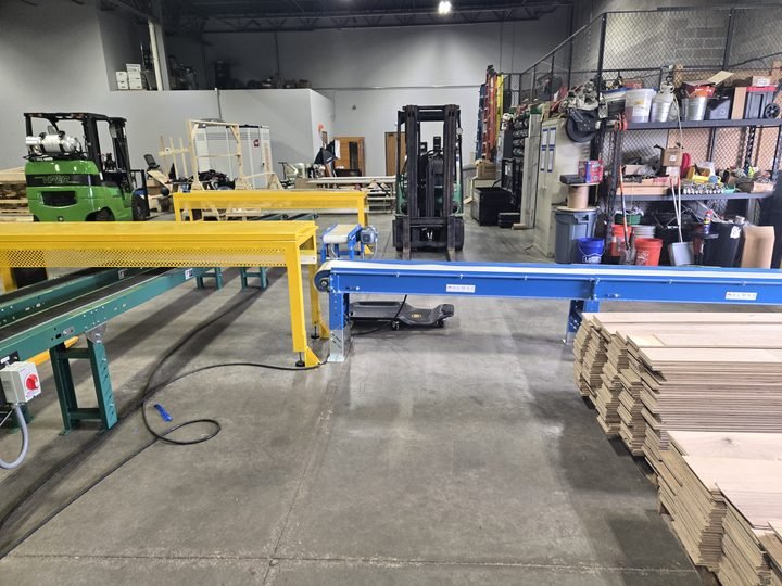 Plant floor reality — gantry, conveyor, product stacked to the ceiling, and about nine inches of clear space to work in.