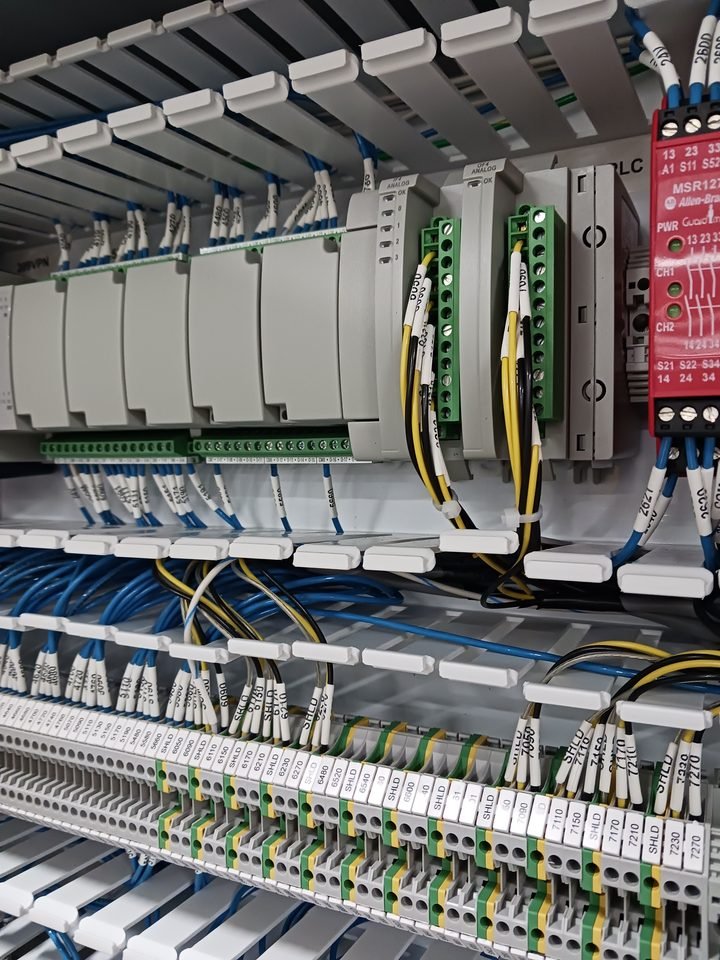 PLC rack with I/O cards populated. Field wiring lands left, logic lives right.