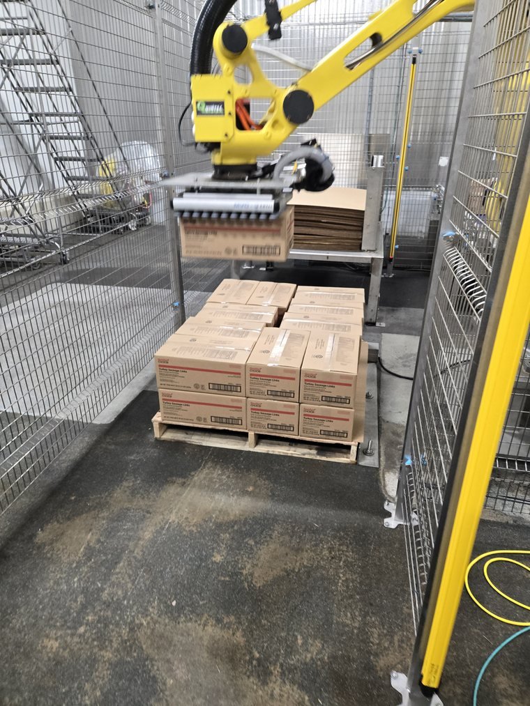 Palletizing. Vacuum head, slip sheet, cartons squared to the pallet edge.