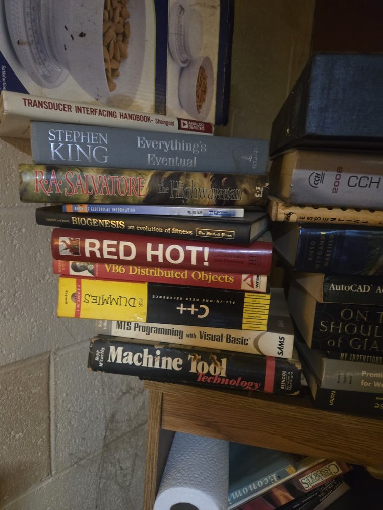 Shelf of technical books including AutoCAD, electronics and programming titles