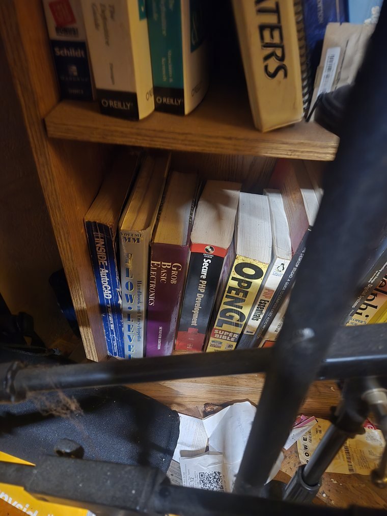 Shelf including a spiral-bound Process Heaters manual and digital systems texts